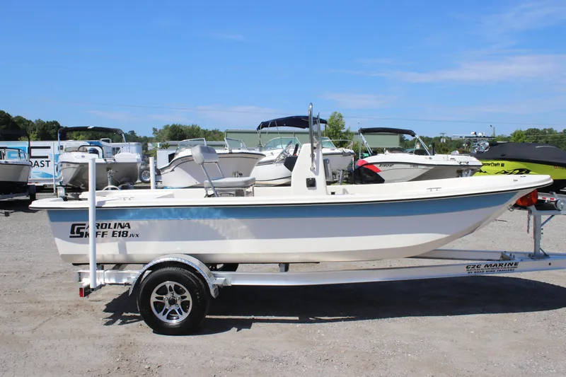Slide: The Image of 2025 Carolina Skiff E18 JVX CC boat on trailer, displayed outdoors. - 5