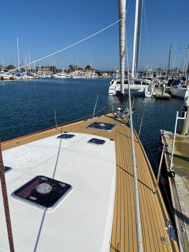 Slide: The Image of 2013 Jeanneau 57 yacht docked in a marina, clear blue sky. - 18
