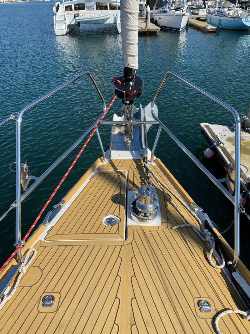 Slide: The Image of 2013 Jeanneau 57 sailboat deck with teak finish, docked at marina. - 21