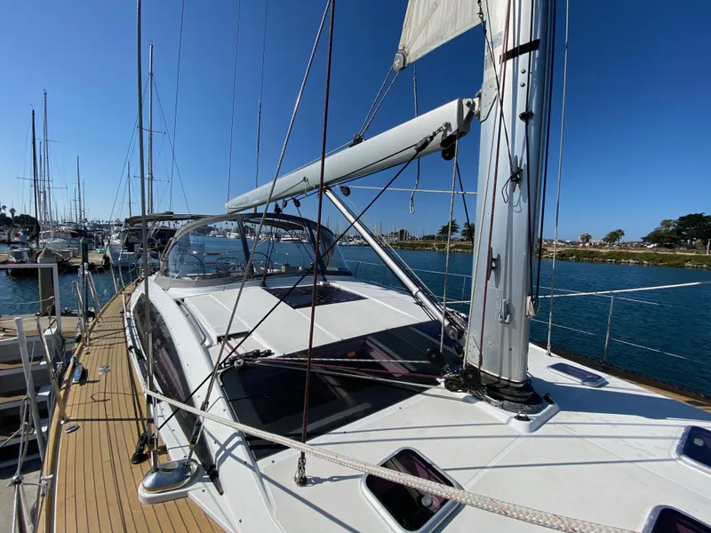 Slide: The Image of 2013 Jeanneau 57 sailboat docked, showcasing sleek design and spacious deck. - 30