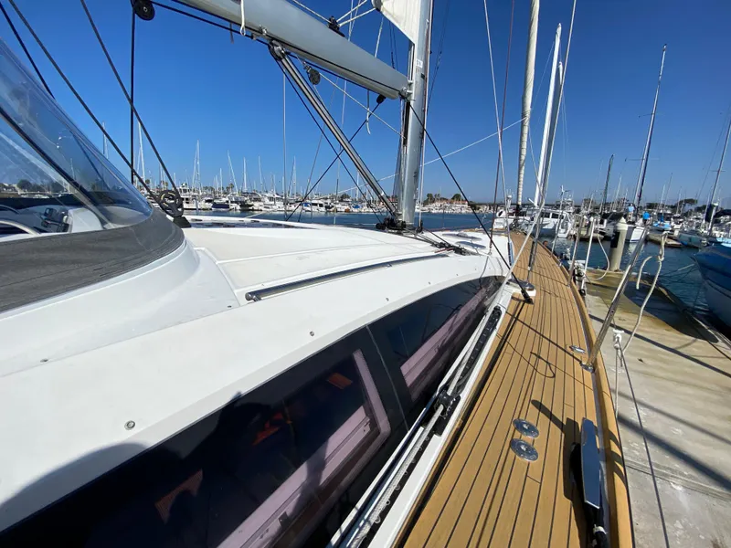 Slide: The Image of 2013 Jeanneau 57 sailboat deck with marina view, clear blue sky. - 9