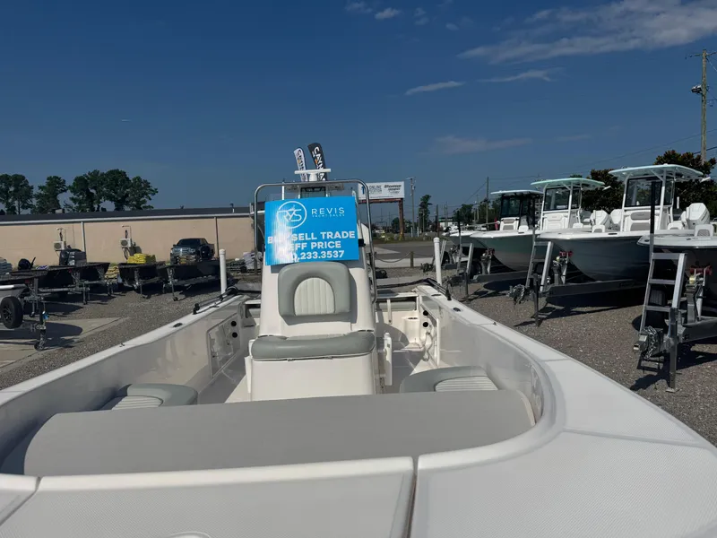 Slide: The Image of 2020 Sundance 20DX boat displayed at dealership with sale sign, surrounded by other boats. - 2