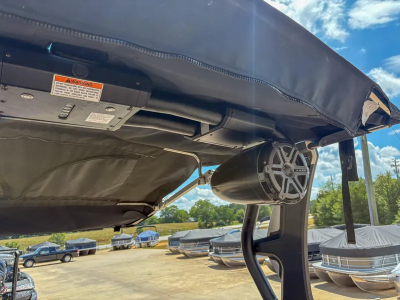Slide: The Image of 2018 Supra SE 450 boat with JL Audio speaker and canopy, parked outdoors. - 13