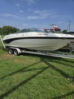 The Image of 2001 Chaparral 230 SSi boat on trailer, parked on grass under clear blue sky. - 0