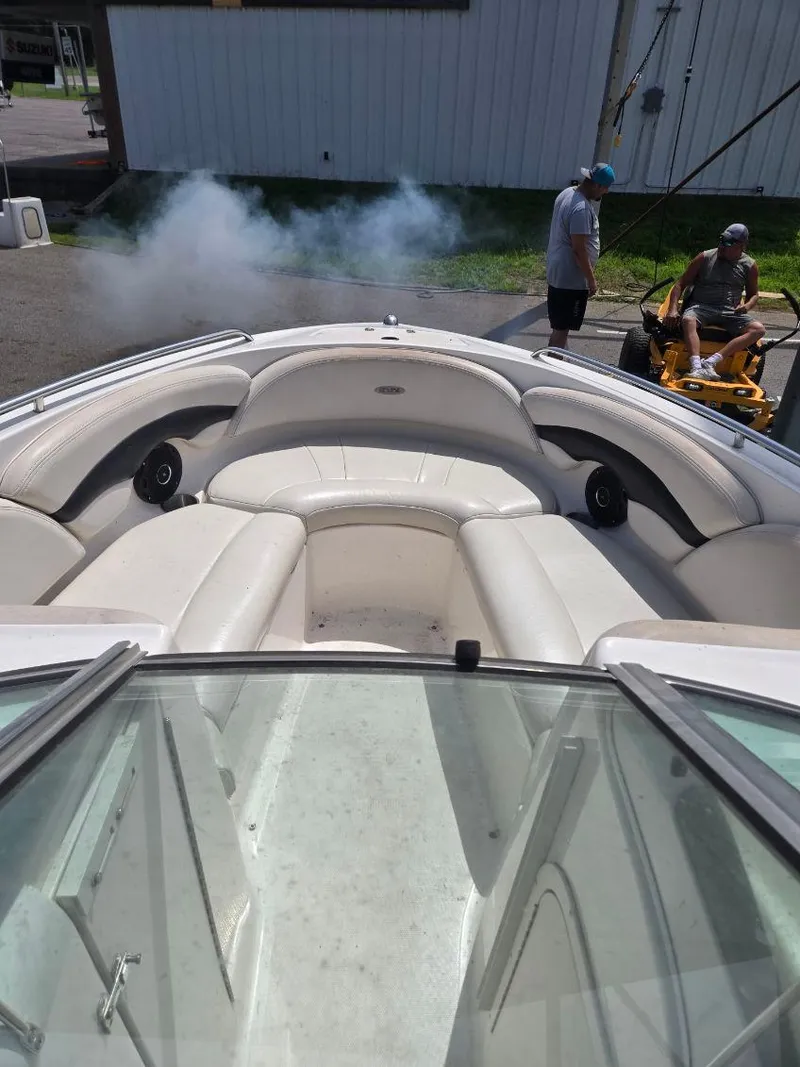 Slide: The Image of 2001 Chaparral 230 SSi boat interior with white seating, parked outdoors. - 8