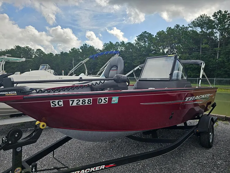 Slide: The Image of 2022 Tracker Pro Guide V-175 WT boat on trailer, red exterior, parked outdoors. - 2
