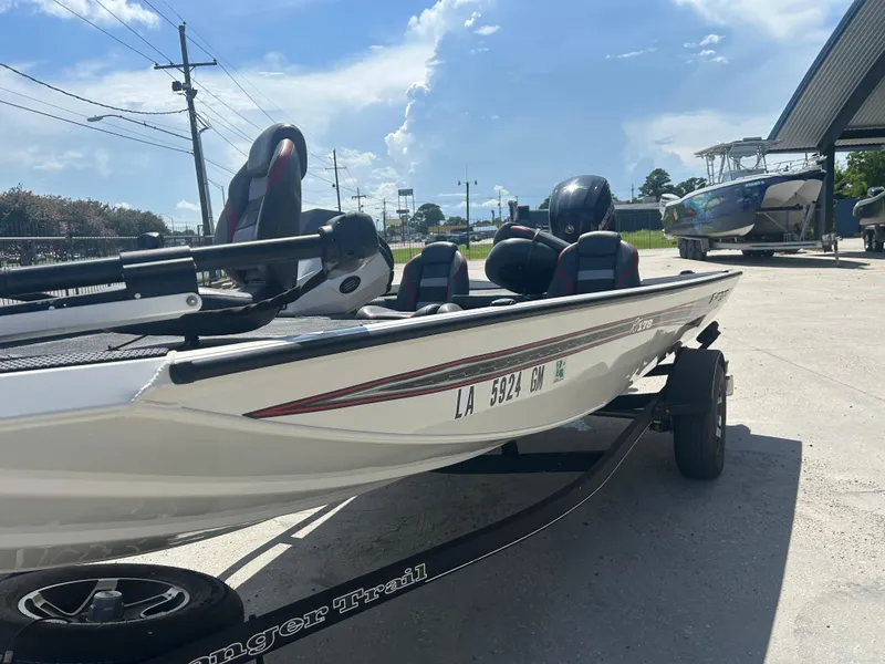 Slide: The Image of 2021 Ranger RT178C boat on trailer under clear blue sky. - 2