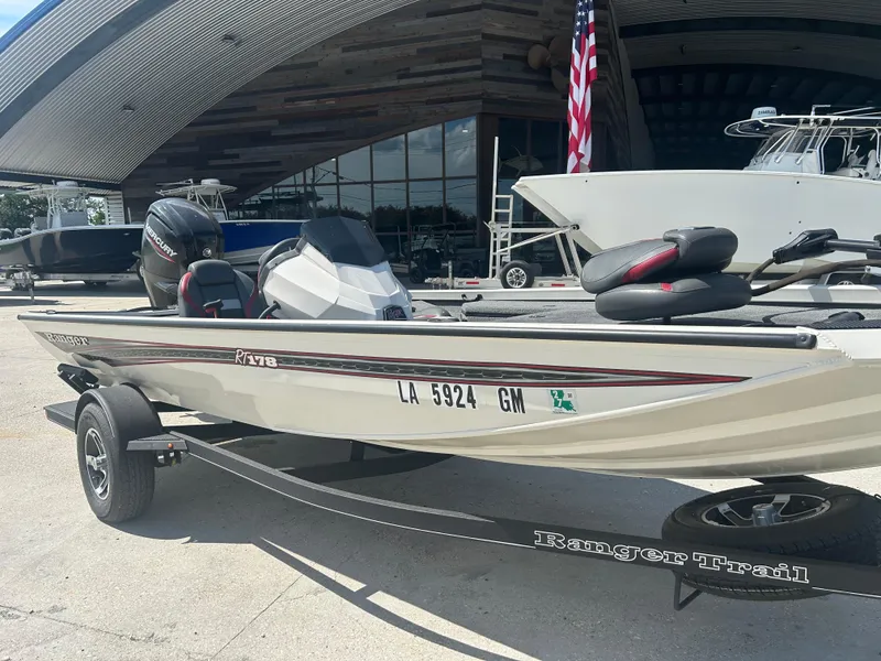 Slide: The Image of 2021 Ranger RT178C boat on trailer, parked outside a modern building. - 4