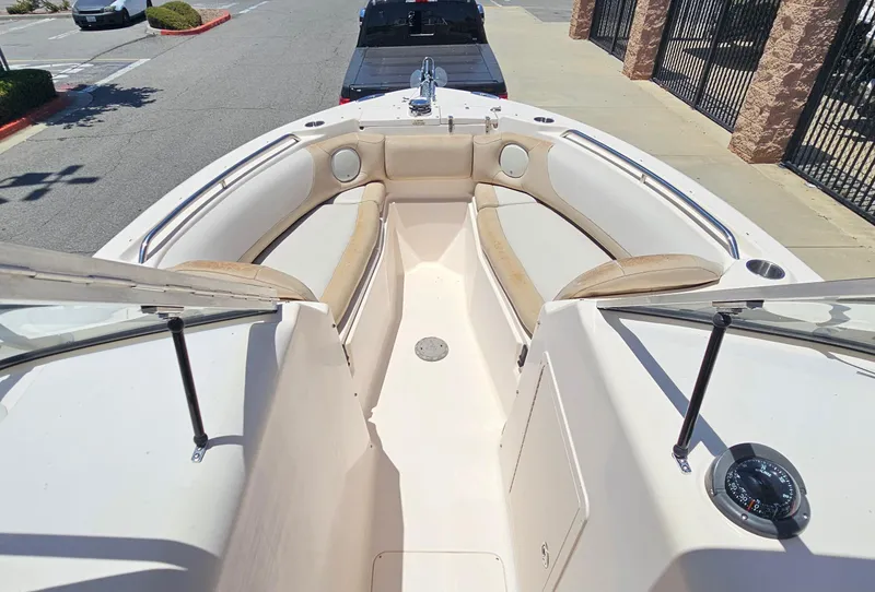 Slide: The Image of 2011 Grady-White Freedom 275 boat interior with seating and compass, parked on pavement. - 10