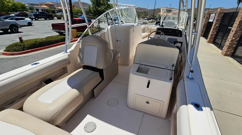 Slide: The Image of 2011 Grady-White Freedom 275 boat interior with seating and console in a parking lot. - 15