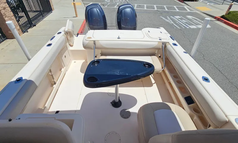 Slide: The Image of 2011 Grady-White Freedom 275 boat interior with seating and table, docked on pavement. - 18