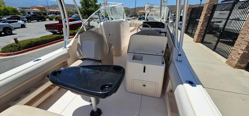 Slide: The Image of 2011 Grady-White Freedom 275 boat interior with seating and table in a parking lot. - 19