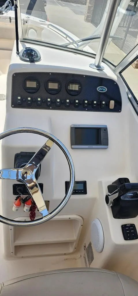 Slide: The Image of 2011 Grady-White Freedom 275 boat dashboard with steering wheel and control panel. - 5