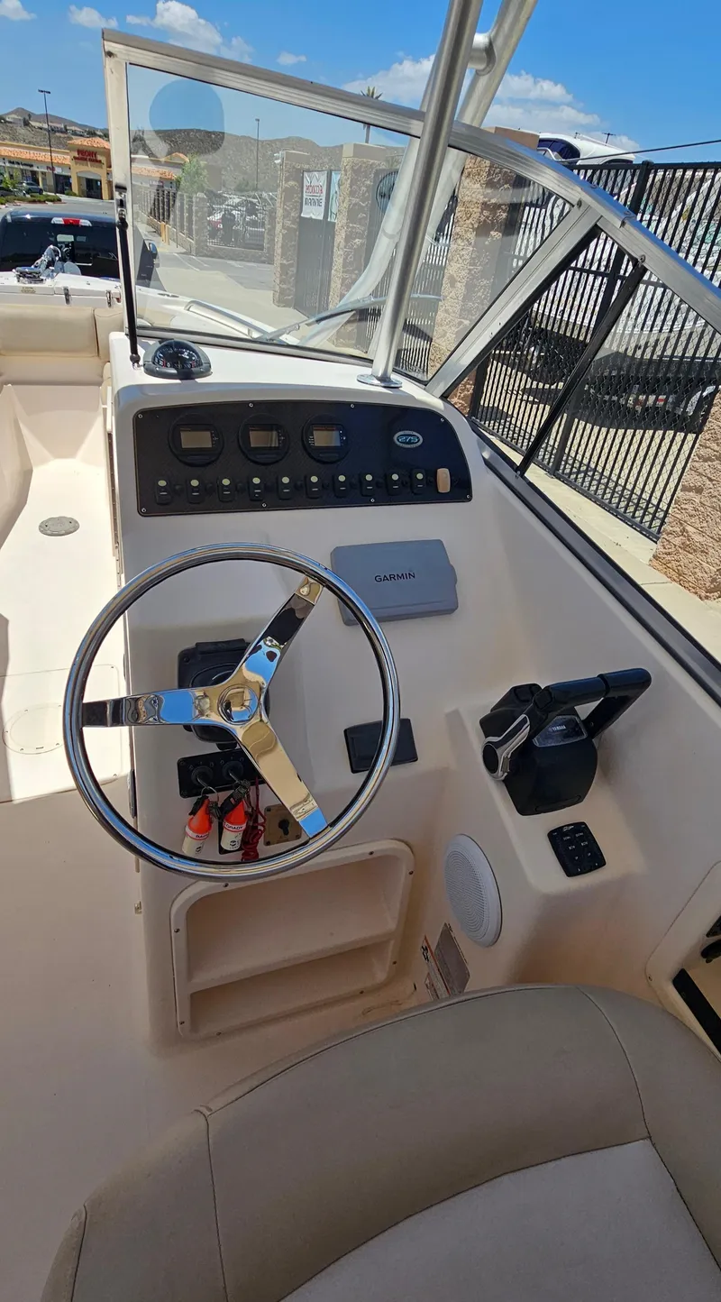 Slide: The Image of 2011 Grady-White Freedom 275 boat cockpit with steering wheel and control panel. - 9