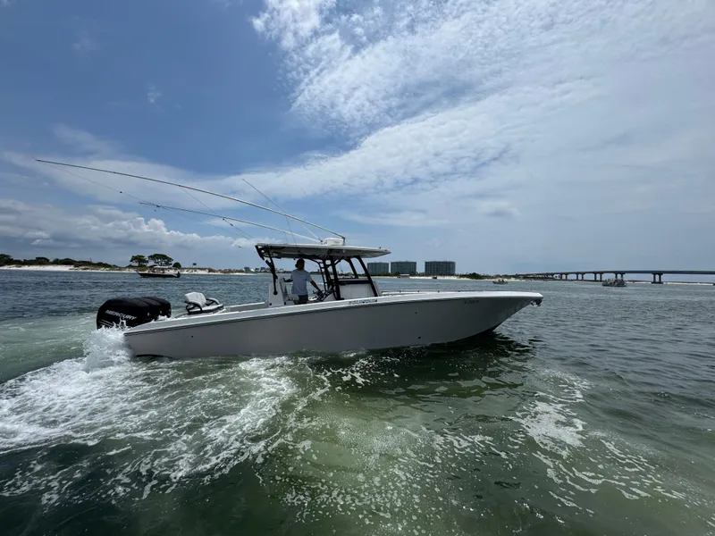 Slide: The Image of 2021 Fountain 38TE boat cruising on open water near a bridge and shoreline. - 13