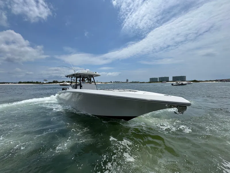 Slide: The Image of 2021 Fountain 38TE boat cruising on open water under a partly cloudy sky. - 17