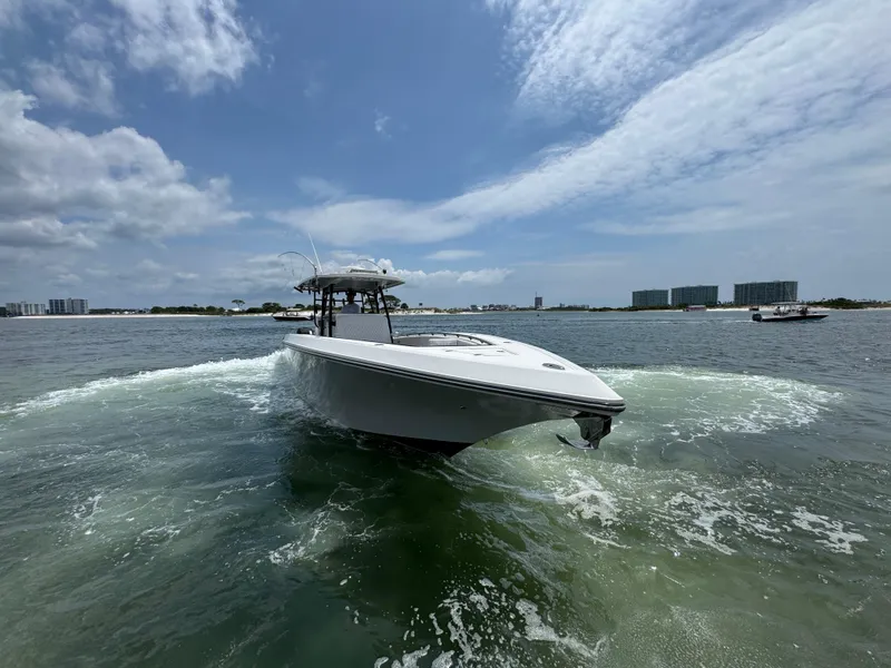 Slide: The Image of 2021 Fountain 38TE boat cruising on open water under a partly cloudy sky. - 18