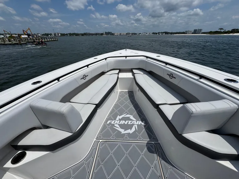 Slide: The Image of Bow seating area of a 2021 Fountain 38TE boat on the water under a cloudy sky. - 21