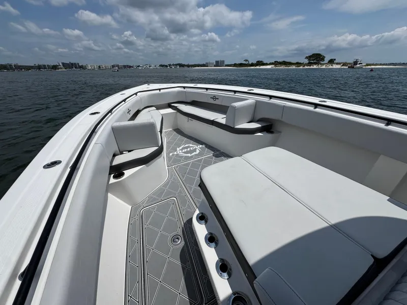 Slide: The Image of 2021 Fountain 38TE boat interior with seating, on calm water under a partly cloudy sky. - 22