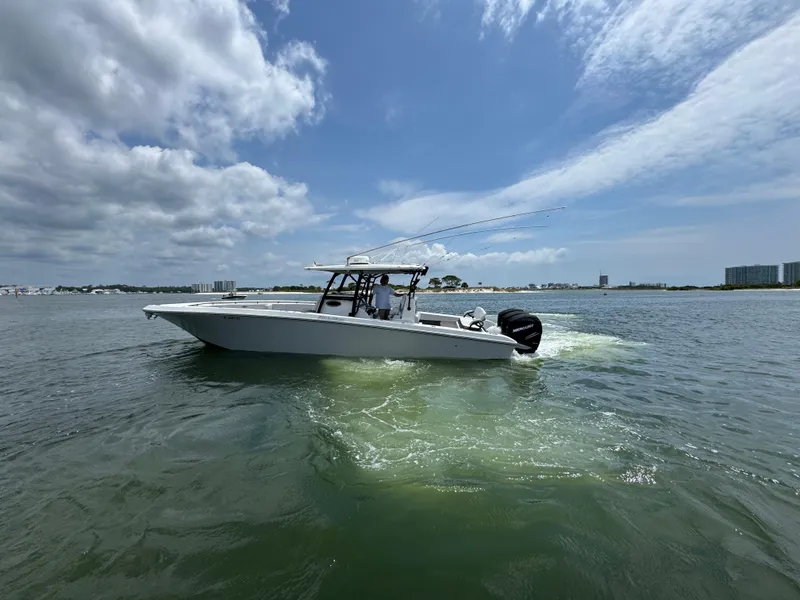 Slide: The Image of 2021 Fountain 38TE boat cruising on open water under a partly cloudy sky. - 3
