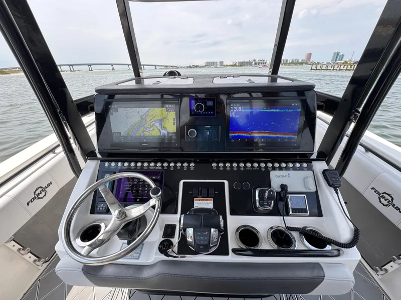 Slide: The Image of Control panel of a 2021 Fountain 38TE boat with navigation screens and steering wheel. - 34
