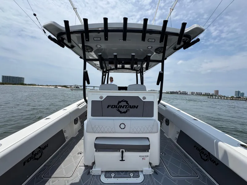 Slide: The Image of Fountain 38TE 2021 boat interior with seating and rod holders on a sunny day. - 37