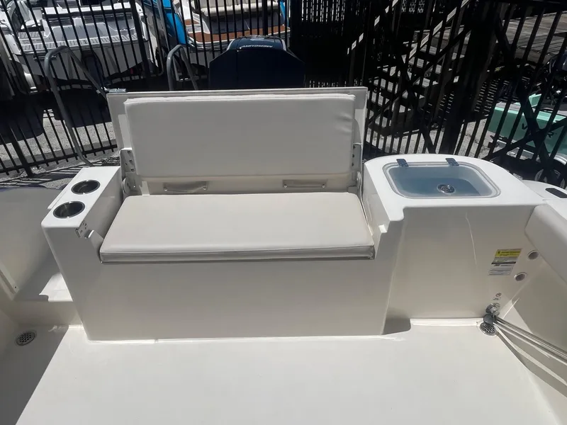 Slide: The Image of 2022 Cobia 220 Dual Console boat interior with seating and sink. - 6