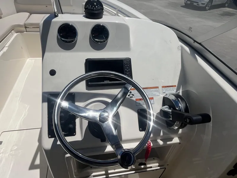 Slide: The Image of 2022 Cobia 220 Dual Console boat dashboard with steering wheel and controls. - 9