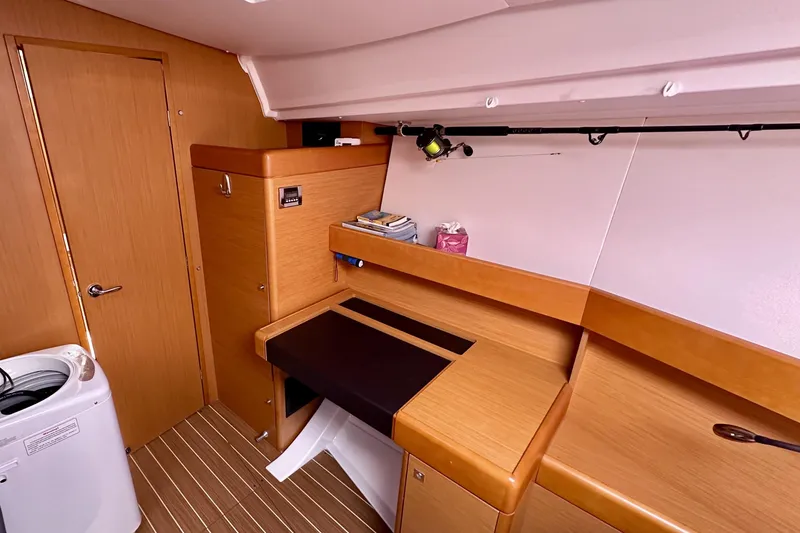Slide: The Image of 2014 Jeanneau Sun Odyssey 44 DS interior with wooden cabinetry and compact workspace. - 16