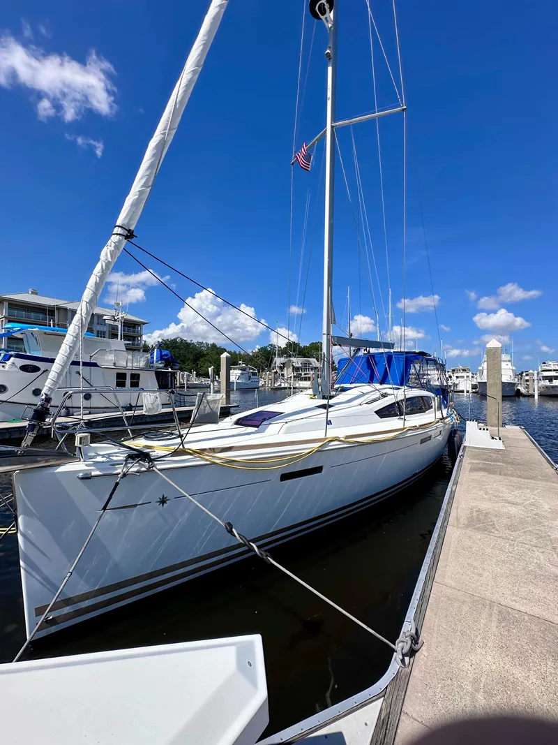 Slide: The Image of 2014 Jeanneau Sun Odyssey 44 DS sailboat docked at marina under clear blue sky. - 2