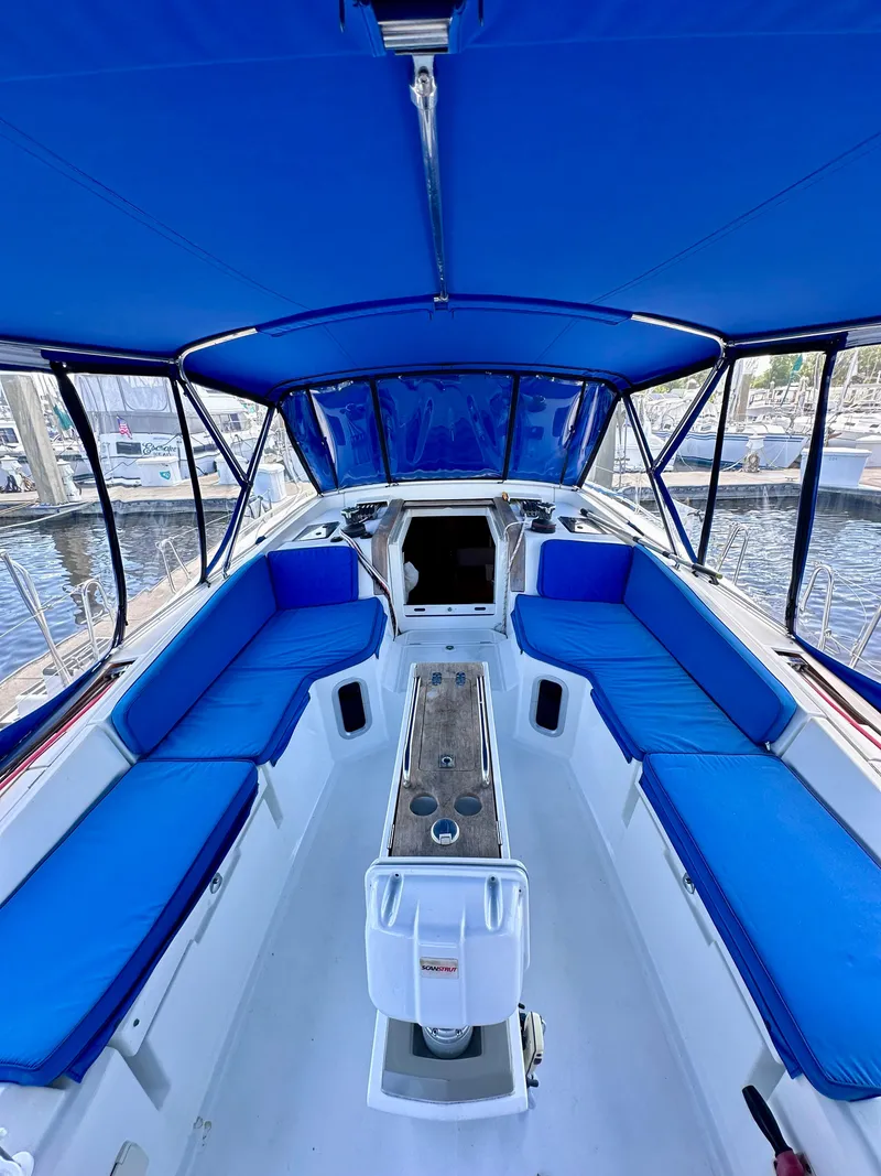 Slide: The Image of 2014 Jeanneau Sun Odyssey 44 DS cockpit with blue seating and canopy, docked at marina. - 7