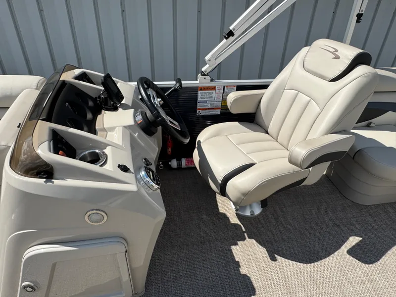 Slide: The Image of 2019 Bennington SX 21 SSRCX boat interior with captain's chair and control panel. - 11
