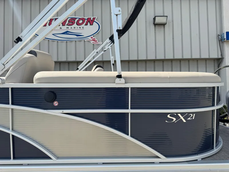 Slide: The Image of 2019 Bennington SX 21 SSRCX pontoon boat side view with blue and beige design. - 7