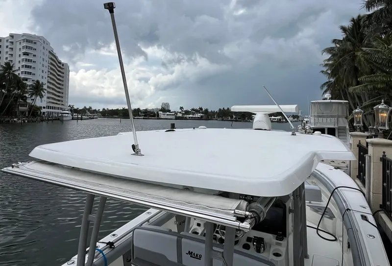 Slide: The Image of 2017 Mako 414 CC Bluewater boat docked by waterfront buildings under cloudy sky. - 10