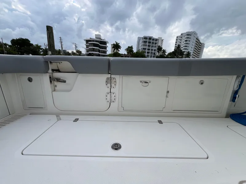 Slide: The Image of 2017 Mako 414 CC Bluewater boat deck with storage compartments, cloudy sky background. - 12