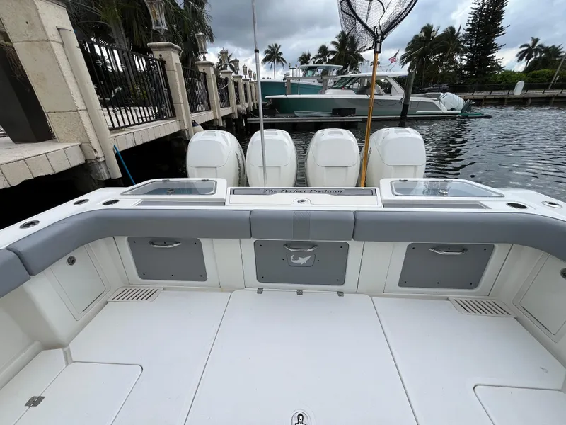 Slide: The Image of 2017 Mako 414 CC Bluewater boat interior with four engines, docked by palm trees. - 15