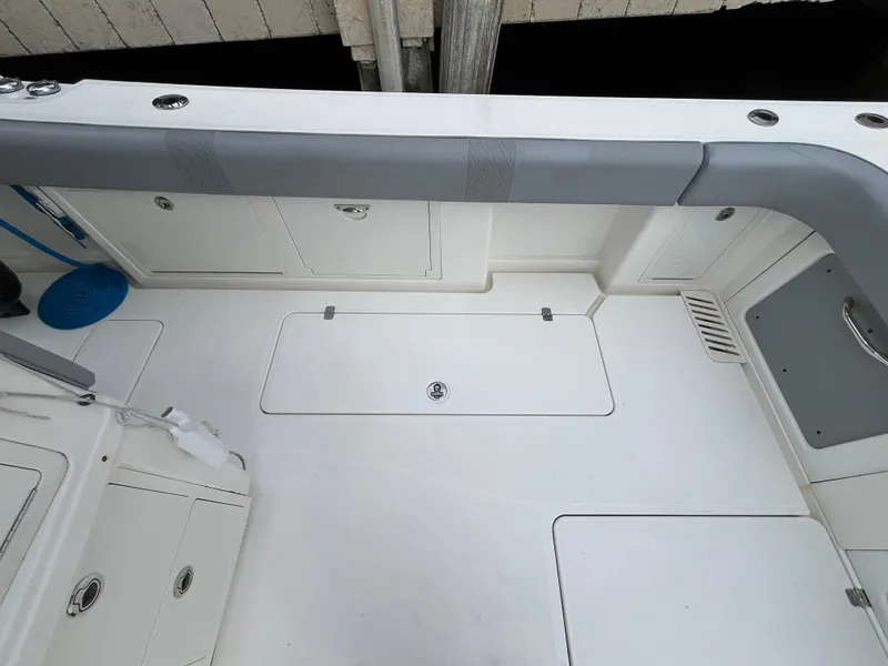 Slide: The Image of 2017 Mako 414 CC Bluewater Family Edition boat deck, featuring storage compartments and seating. - 19