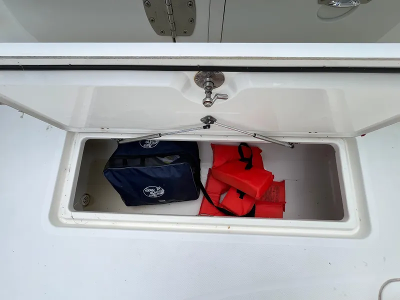 Slide: The Image of Open storage compartment on 2017 Mako 414 CC boat with life jackets and gear. - 29