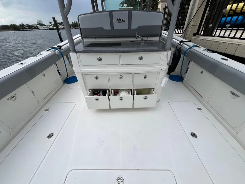 Slide: The Image of 2017 Mako 414 CC Bluewater boat interior with storage drawers open, docked by the water. - 40