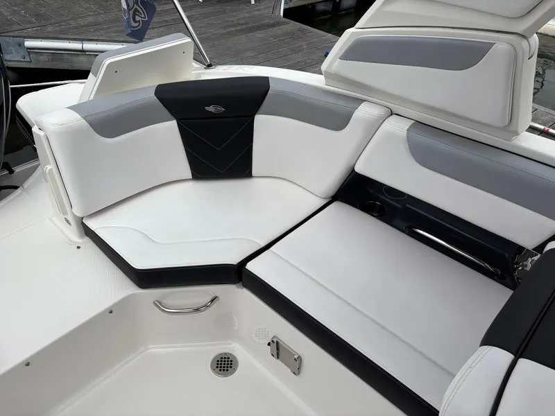 Slide: The Image of 2020 Chaparral 250 Suncoast boat interior seating with sleek white and gray upholstery. - 11