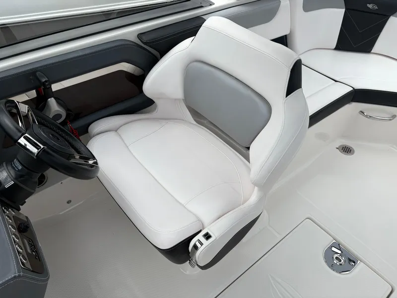 Slide: The Image of 2020 Chaparral 250 Suncoast boat interior with white seating and steering wheel. - 16