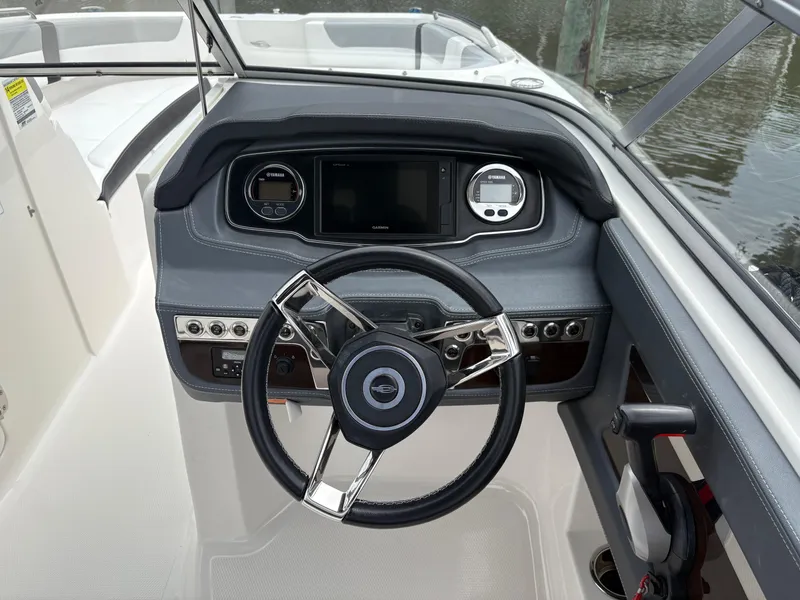 Slide: The Image of 2020 Chaparral 250 Suncoast boat dashboard with steering wheel and controls. - 18