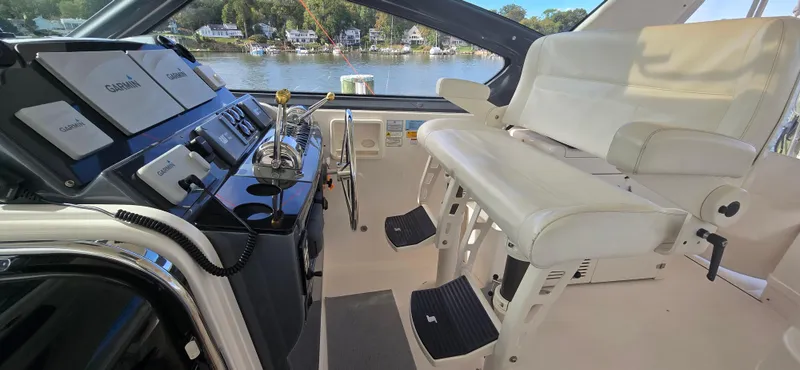 Slide: The Image of 2004 Tiara Yachts 5200 Sovran helm with Garmin navigation, dual seats, and waterfront view. - 11