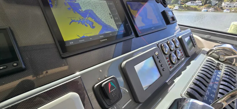 Slide: The Image of Helm of 2004 Tiara Yachts 5200 Sovran with navigation screens and controls. - 12
