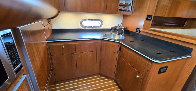 Slide: The Image of 2004 Tiara Yachts 5200 Sovran kitchen with wood cabinetry and sleek countertops. - 20