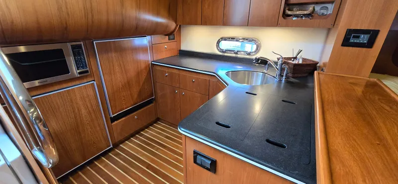 Slide: The Image of Luxurious 2004 Tiara Yachts 5200 Sovran kitchen with wood cabinetry and modern appliances. - 21