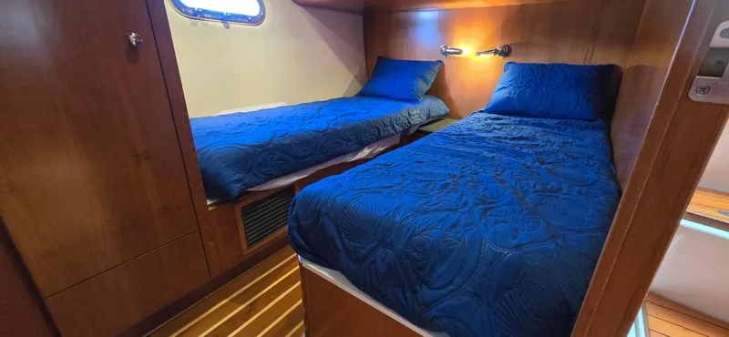Slide: The Image of 2004 Tiara Yachts 5200 Sovran cabin with twin beds and blue bedding. - 23