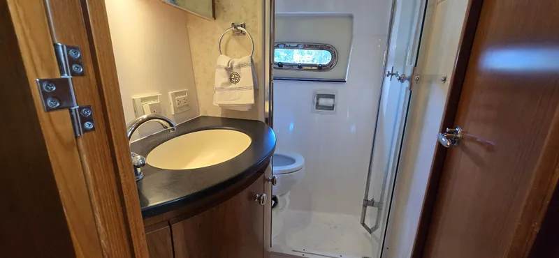 Slide: The Image of 2004 Tiara Yachts 5200 Sovran bathroom with sink, toilet, and shower. - 25