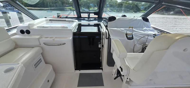 Slide: The Image of 2004 Tiara Yachts 5200 Sovran cockpit with helm, seating, and water view. - 3