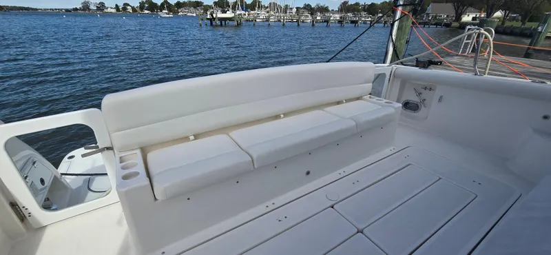 Slide: The Image of 2004 Tiara Yachts 5200 Sovran, spacious deck with white seating, docked by the water. - 7